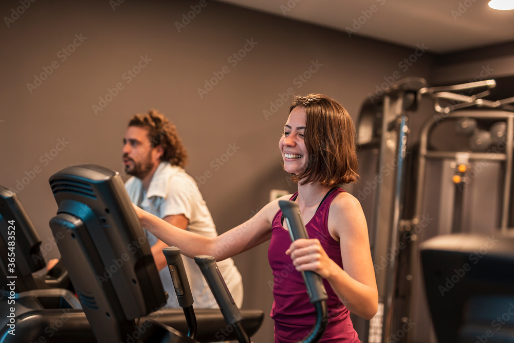 Fototapeta premium People using ski machine while working out in gym