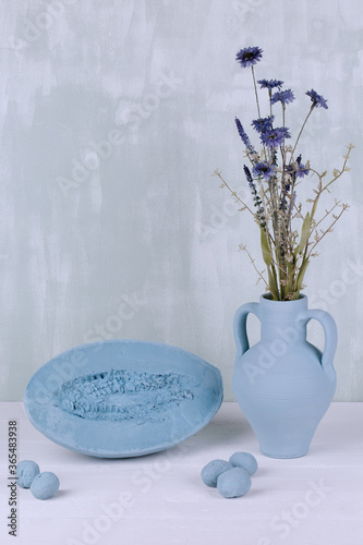Bouquet of flowers in a blue vase on a white background with nuts and watermelon