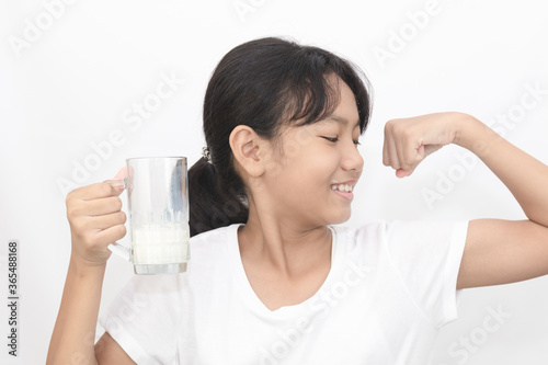 Portrait of Asian cute girl drinking milk from a glass on white background