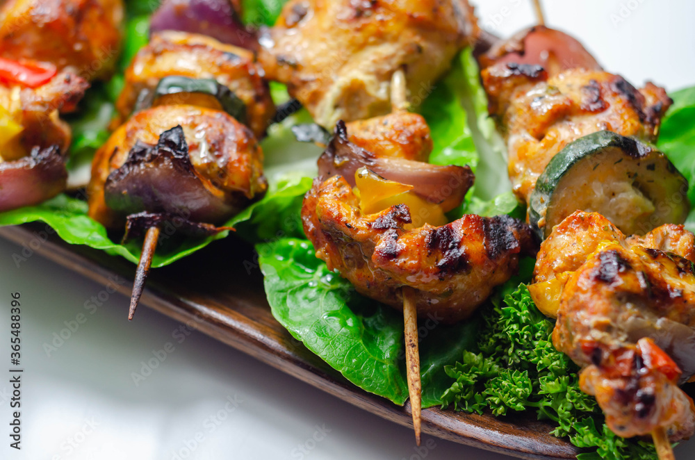 Grilled skewers with chicken, zucchini, mushrooms, peppers and onions served on iceberg lettuce