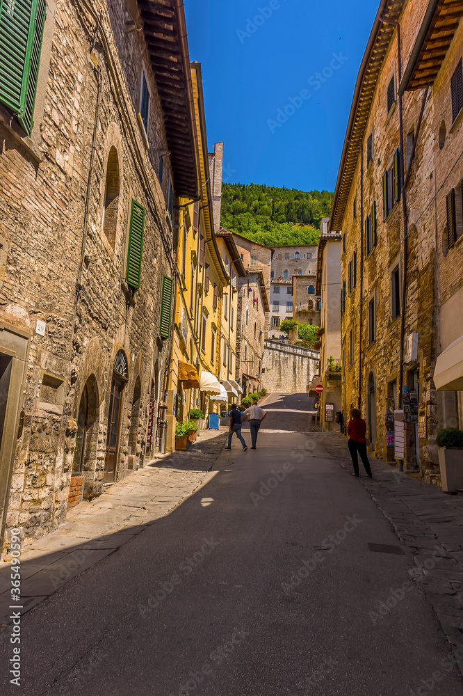 A view up a hillside street in the cathedral city of Gubbio, Italy in summer