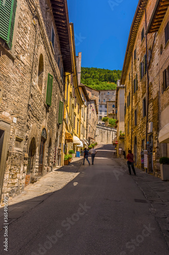 Fototapeta Naklejka Na Ścianę i Meble -  A view up a hillside street in the cathedral city of Gubbio, Italy in summer