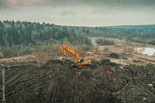 Reclamation of solid waste landfill by heavy machinery