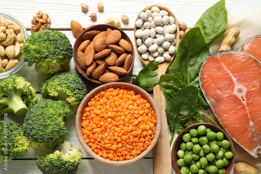 Products rich in protein on white wooden table, flat lay Products rich in protein on white wooden table, flat lay