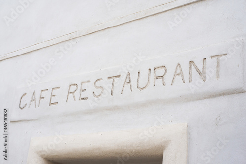 Closeup of cafe restaurant sign on stoned wall of building facade in the street