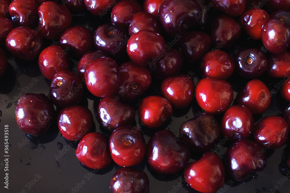 Close-up of wet ripe sweet cherry on a black background Close-up of wet ripe sweet cherry on a black background