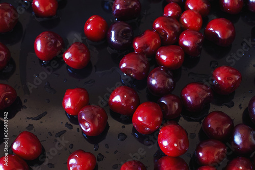 Close-up of wet ripe sweet cherry on a black background