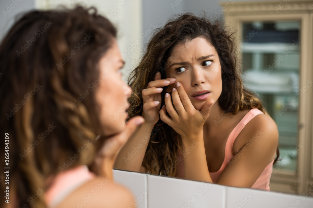 Beautiful woman squeezing pimple in the bathroom. Beautiful woman squeezing pimple in the bathroom.