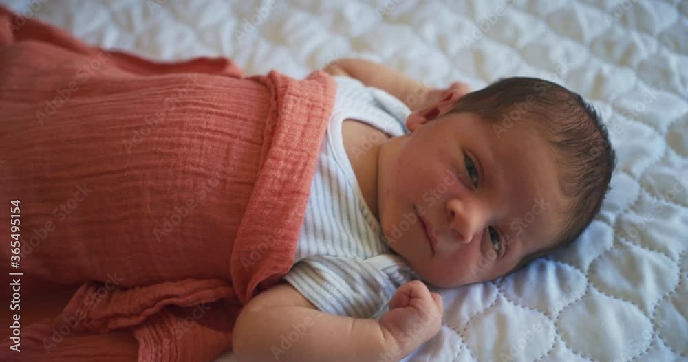 Newborn baby wrapped up in musllin on bed Newborn baby wrapped up in musllin on bed