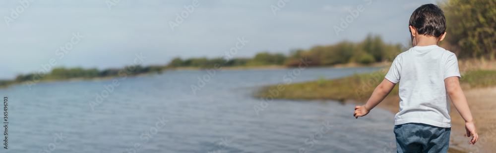 website header of boy standing and gesturing near pond