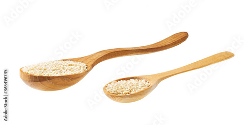 sesame seeds on a wooden spoon isolated on white background .