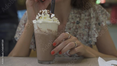 chocolate frappe or frapuccino with woman hand stirring iced. Close-up and selective focus. photo