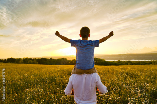 Принти на полотні happy family of father and child on field at the sunset having fun