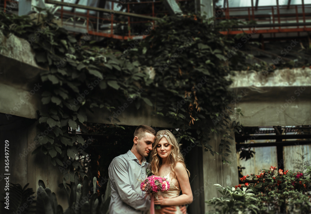young couple posing in a botanical garden. wedding photo session with tropical plants.