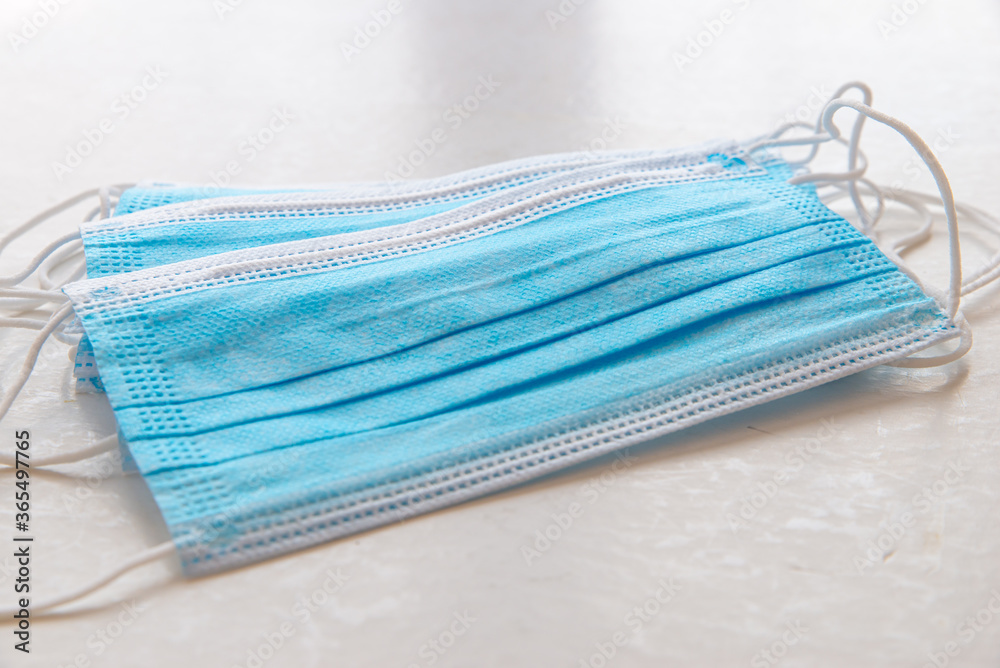Blue surgical masks on white table Blue surgical masks on white table