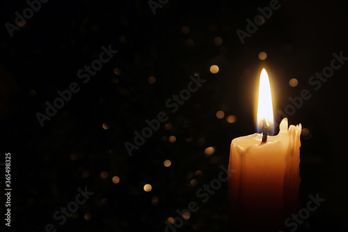 Candles Burning at Night. White Candles Burning in the Dark with focus on single candle in foreground.