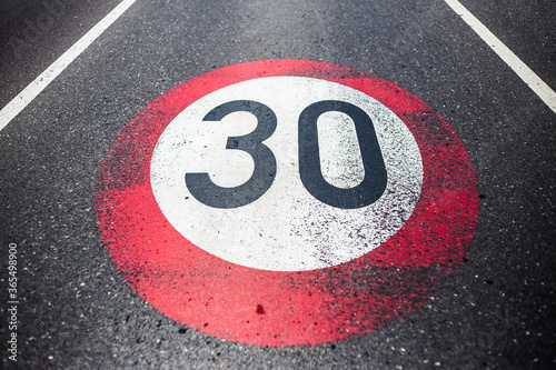 30km/h speed limit sign painted on asphalting road. © Lalandrew
