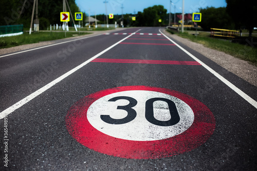 30km/h speed limit sign painted on asphalting road. photo