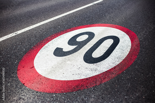 90km/h speed limit sign painted on asphalting road. © Lalandrew