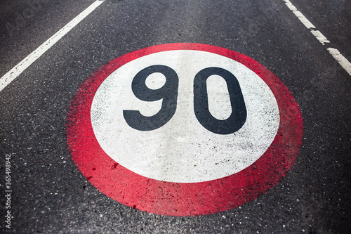 90km/h speed limit sign painted on asphalting road. © Lalandrew