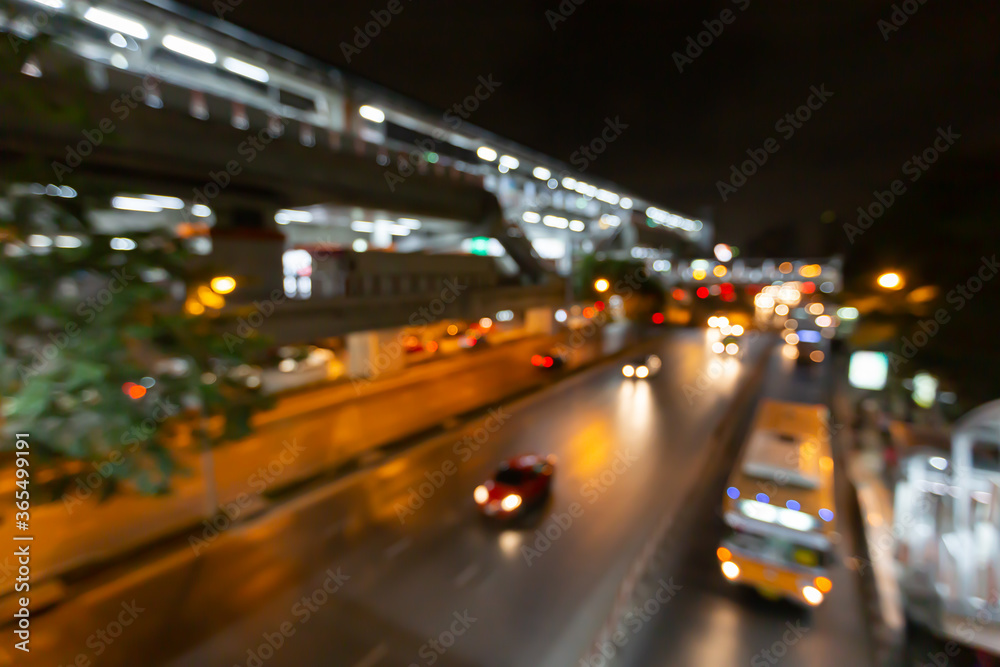 Abstract blurred traffic city of Night market on street light bokeh background. Bangkok, Thailand Cityscape at twilight time concept: focus in Motion blur,  Modern business building estate nightlife.