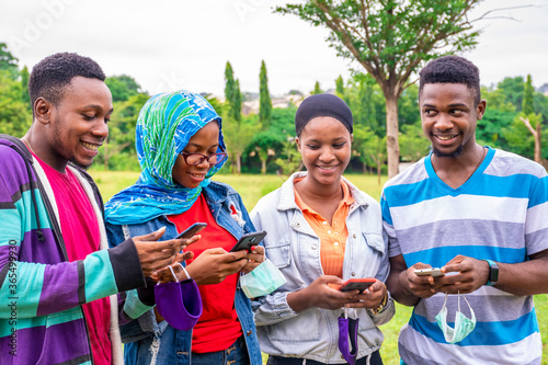 a group of young black people using their mobile phones simultaneously