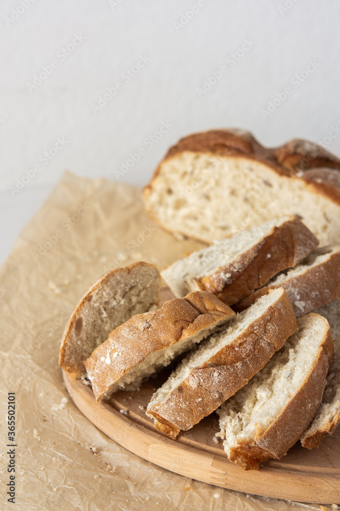 Loaf of homemade bread with sliced bread from wheat and seeds on parchment paper Loaf of homemade bread with sliced bread from wheat and seeds on parchment paper