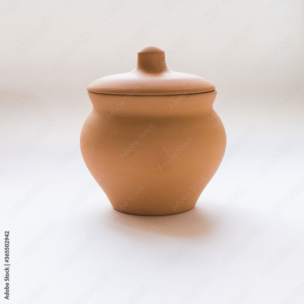 brown ceramic pot with lid on white background