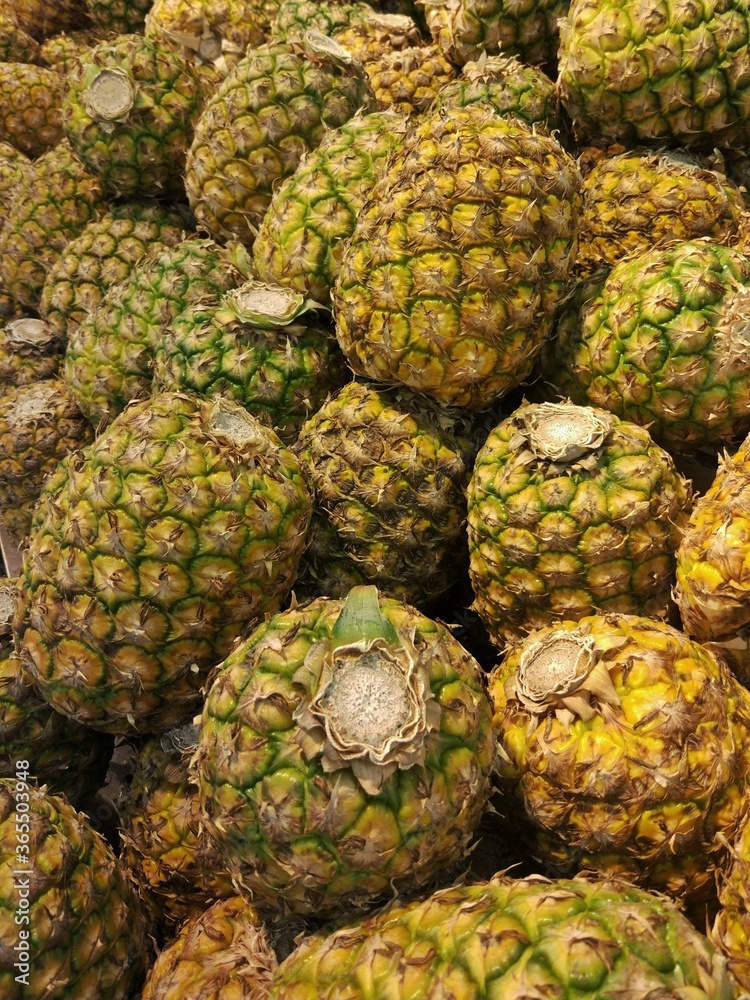 A lot of pineapple fruit at market store. Tropical fruit background A lot of pineapple fruit at market store. Tropical fruit background