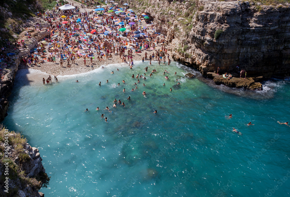 People relax and swimming on lovely beach Lama Monachile in Polignano a Mare
