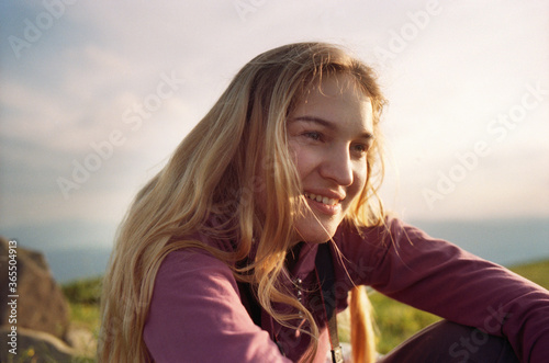 Young Caucasian blond woman resting in the mountains in summer. Film