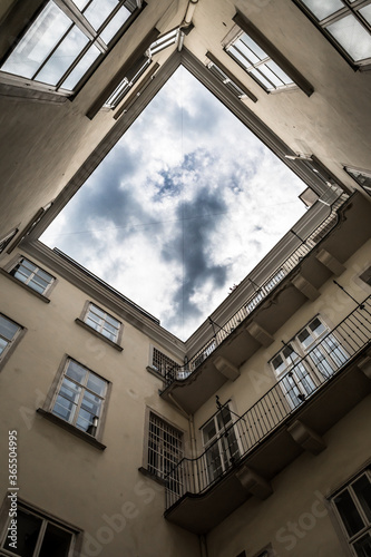 Narrow Courtyard With View Up To The Cloudy Sky Of A Historic Building © grafxart