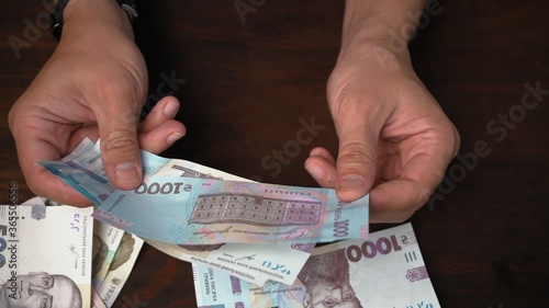 Male hands holding pack of new Ukrainian banknotes face value 1000 hryvnia. Credit concept. Wealth concept. Close up chot.