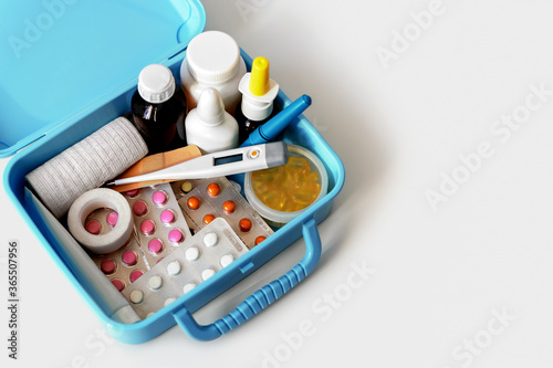Pills, capsules, blisters, nose sprays, bottles, patches and electronic thermometer in home medical chest. Health care and medicaments keeping concept. Close up, copy space for text