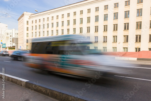 The movement of a blurred minibus along the overpass in the daytime.
