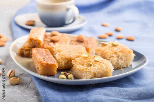 traditional arabic sweets and a cup of coffee on a gray concrete background. side view  selective focus.