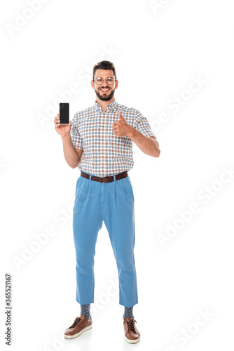 Smiling nerd holding smartphone with blank screen and showing thumb up on white background © LIGHTFIELD STUDIOS