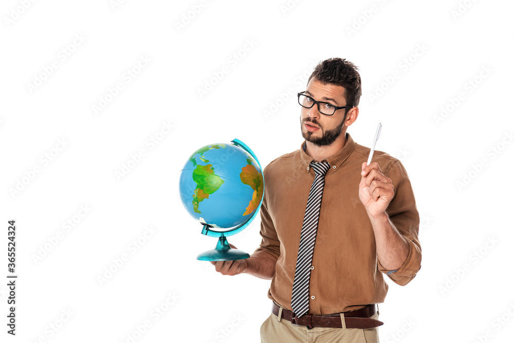 Fototapeta premium Handsome bearded teacher looking at camera and holding globe with pen isolated on white