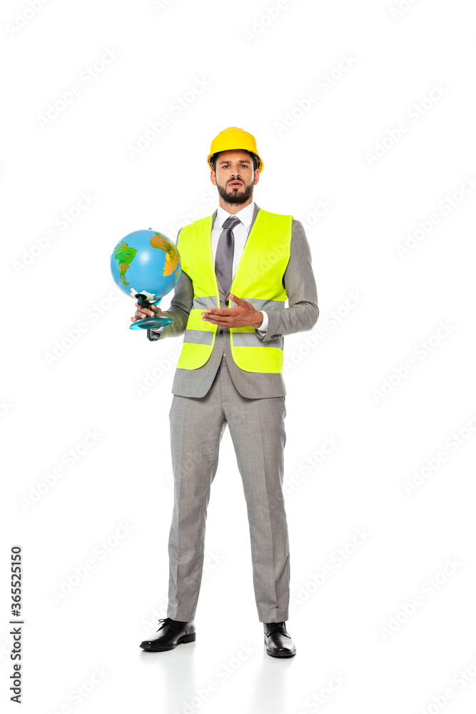 Handsome engineer in suit and hardhat pointing with hand at globe on white background Handsome engineer in suit and hardhat pointing with hand at globe on white background