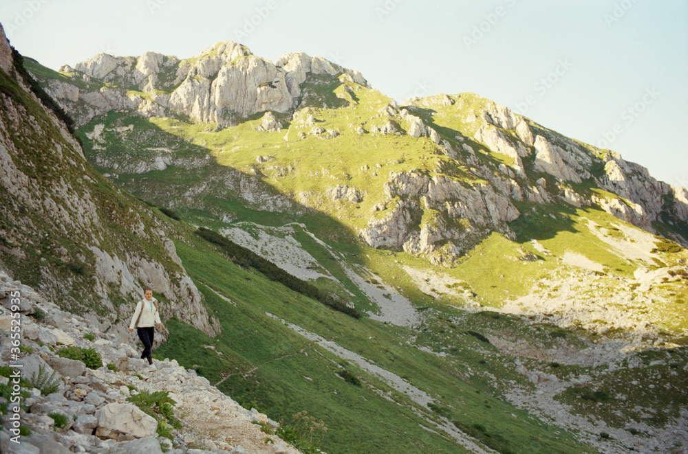 Obraz premium Young Caucasian woman traveling in the mountains of Durmitor National Park in Montenegro. Real grain scanned film.