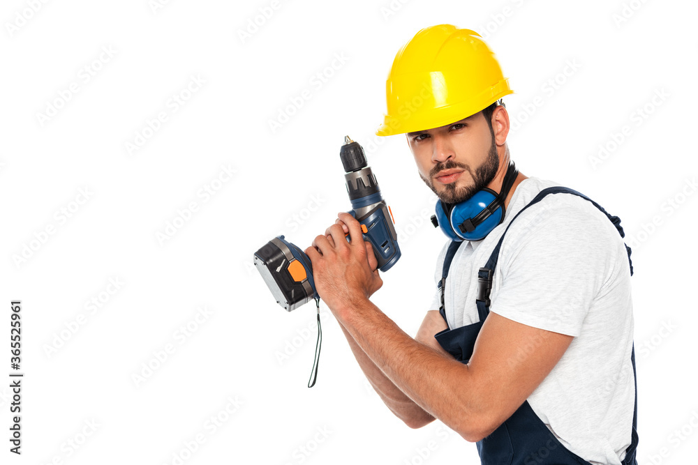 Handsome workman in hardhat and ear defenders holding electric screwdriver isolated on white Handsome workman in hardhat and ear defenders holding electric screwdriver isolated on white