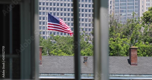 American flag waves over Governors Island in New York City on a clear day.