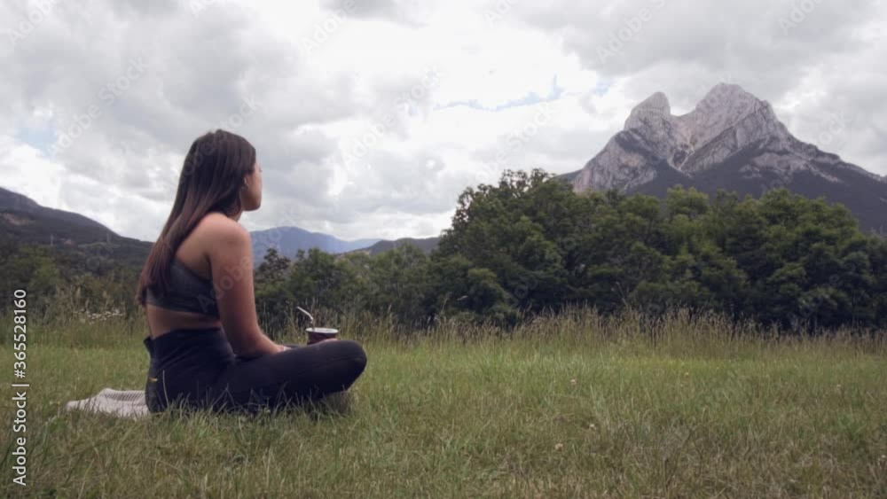 Attractive girl sitting on the grass drinking Argentinean mate (traditional infusion). Relaxed woman taking a break after doing Yoga, admiring the beautiful landscape in Pedraforca, Catalonia
Attractive girl sitting on the grass drinking Argentinean mate (traditional infusion). Relaxed woman taking a break after doing Yoga, admiring the beautiful landscape in Pedraforca, Catalonia