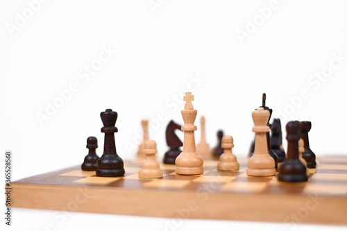 Chess board game with focus on white queen pieces on white background