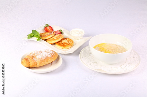 Cheesecakes  oatmeal and croissant on white background