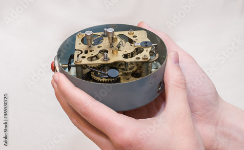 open old clock mechanism holding in  a hand photo