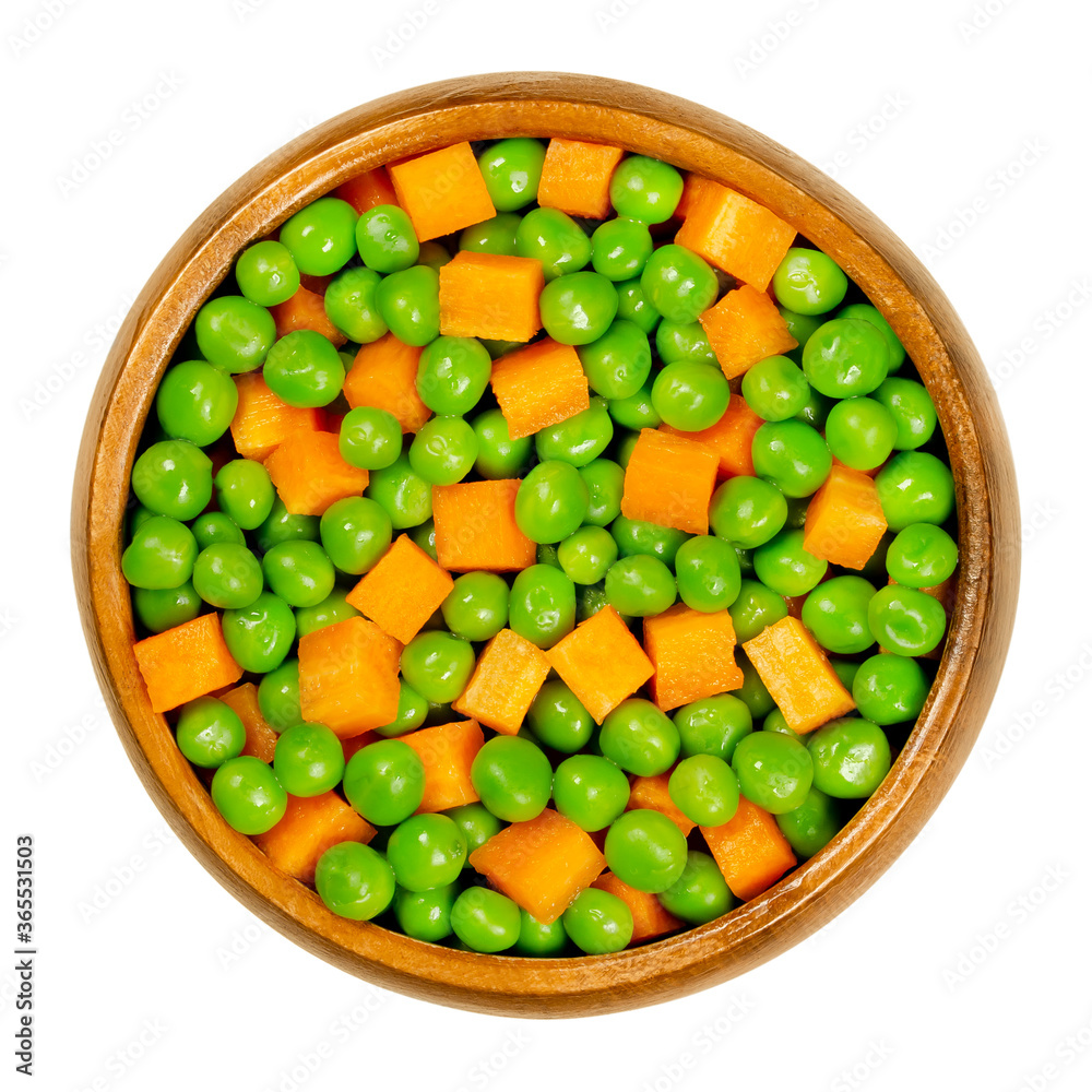 Green peas and carrot cubes in wooden bowl. Mixed vegetables. Seeds of