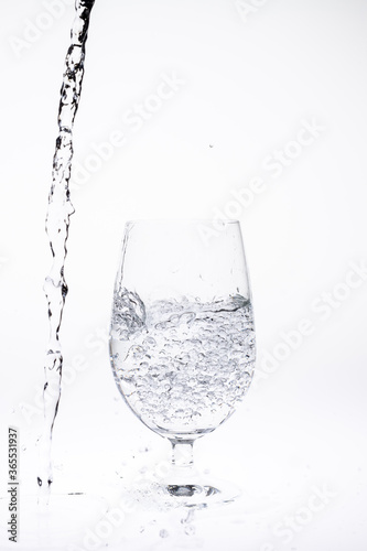 Pour water in glass isolated on white background.