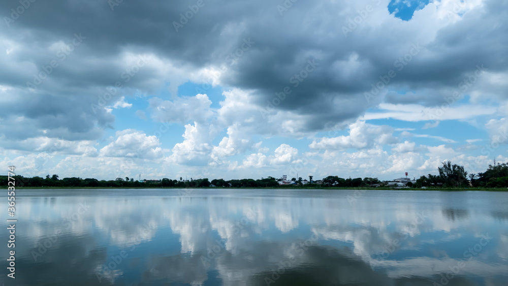 White clouds floating in the sky With the shadow of clouds reflecting on the water surface