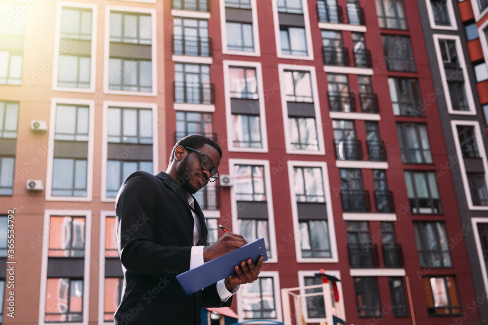 A young African-American engineer draws on a construction site. A young African-American engineer draws on a construction site.